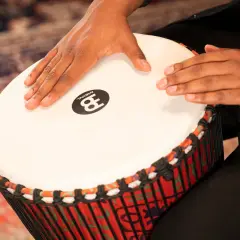 Dłonie grają na djembe, etnicznym rodzaju bębna.