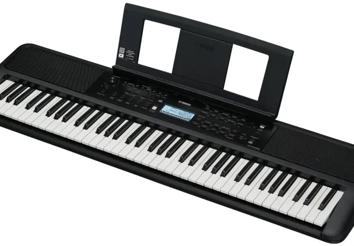 Czarny keyboard Yamaha z nutami na stojaku. To świetne narzędzie do nauki gry na instrumencie.