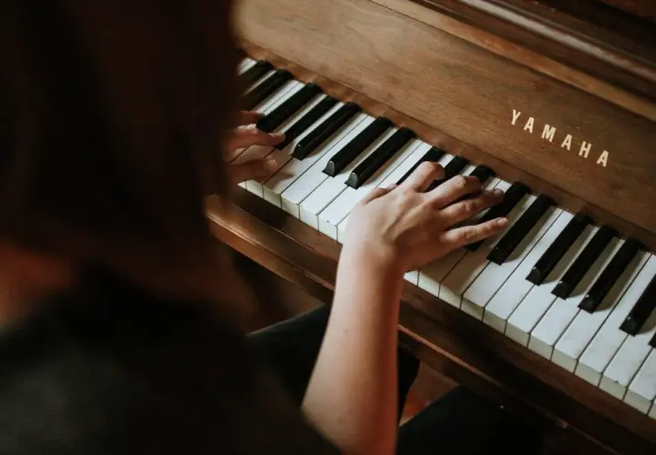 Dłonie grają na pianinie Yamaha, tworząc melodię e dur piano.