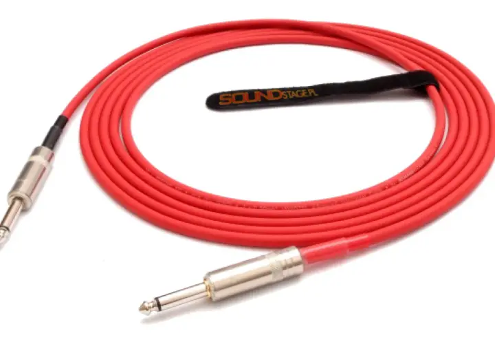 Czerwony kabel do gitary elektrycznej z wtykami jack. Idealny do podłączenia instrumentu, zapewniający czysty dźwięk.