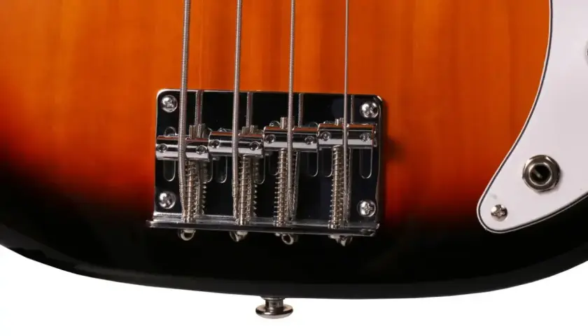 Zbliżenie na mostek i struny gitary basowej elektrycznej w kolorze sunburst.