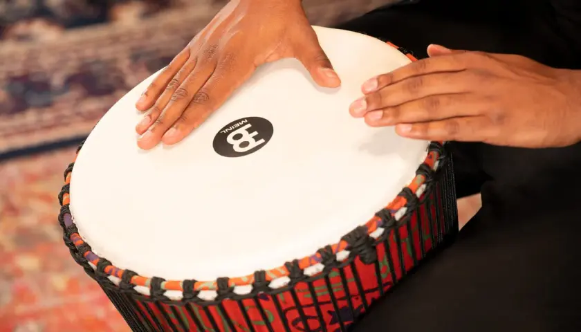 Dłonie grają na djembe, etnicznym rodzaju bębna.