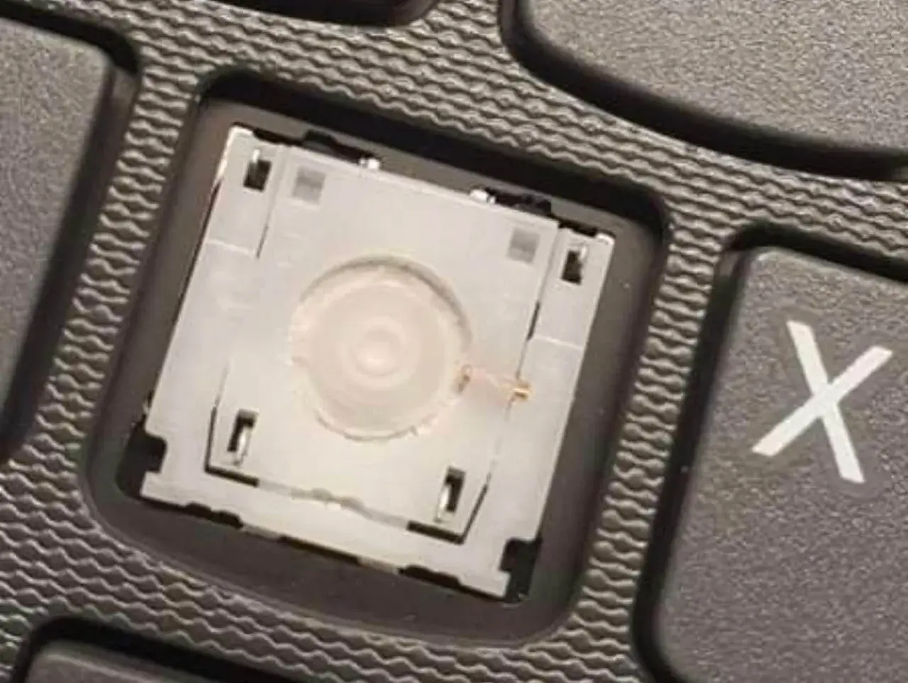 Mechanizm klawisza po naprawie keyboardów. Widoczny detal mechanizmu klawiatury, gotowy do montażu.
