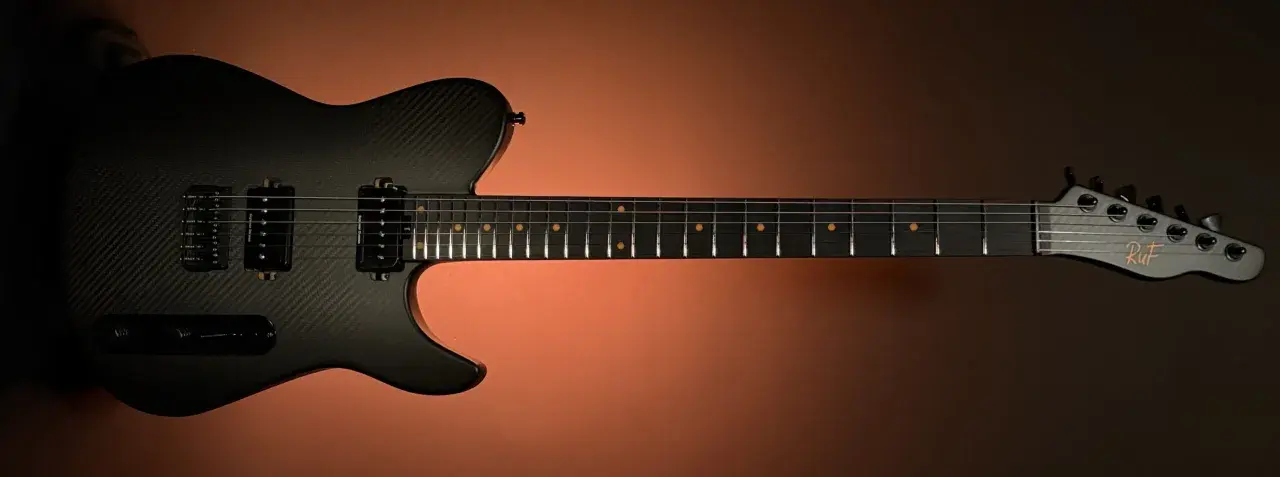 Czarna gitara elektryczna z włókna węglowego z logo "RuF" na główce. Wyjątkowe instrumenty Ruf Guitars.