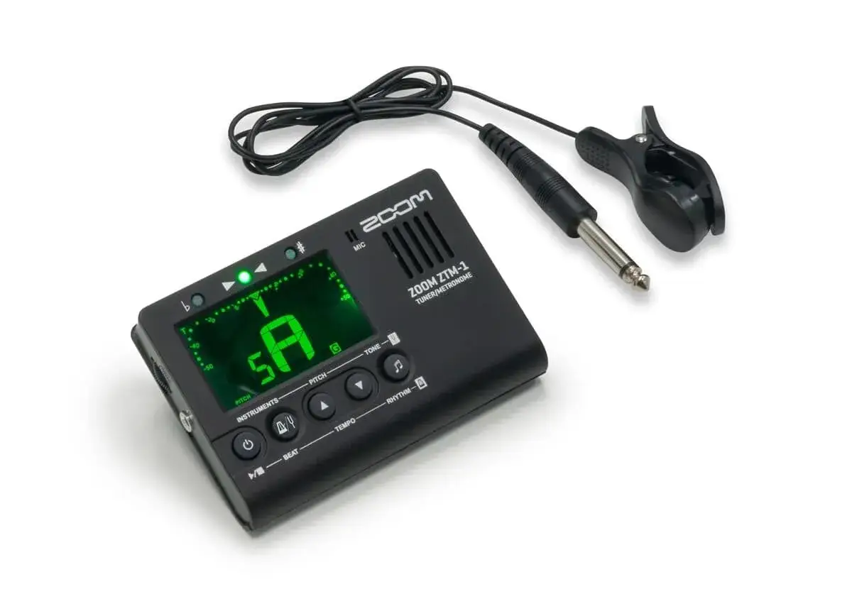 Elektroniczny metronom do gitary Zoom ZTM-1 z klipsem do strojenia. Zielony wyświetlacz pokazuje literę 